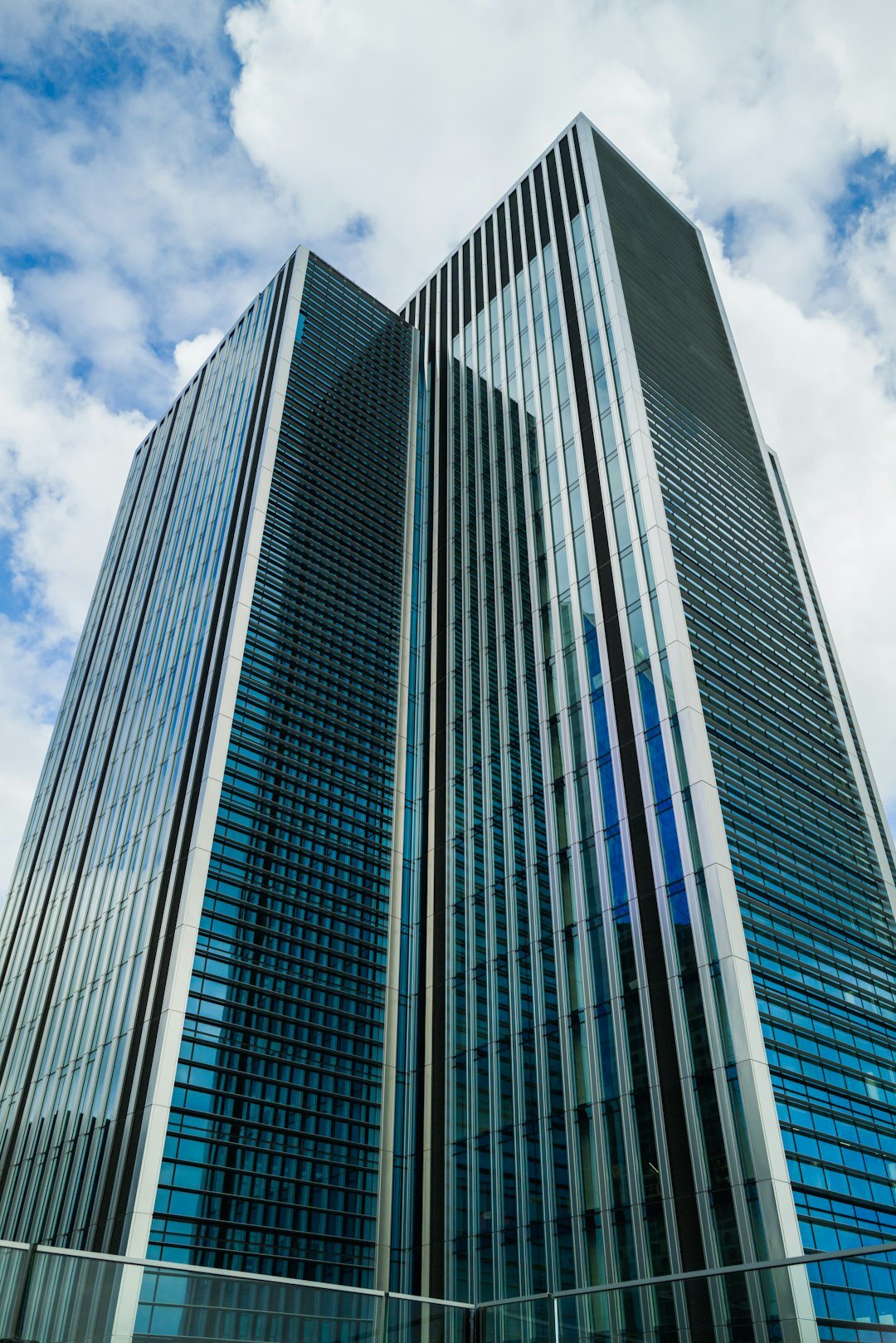 Glass corporate skyscraper facade reflecting the sky